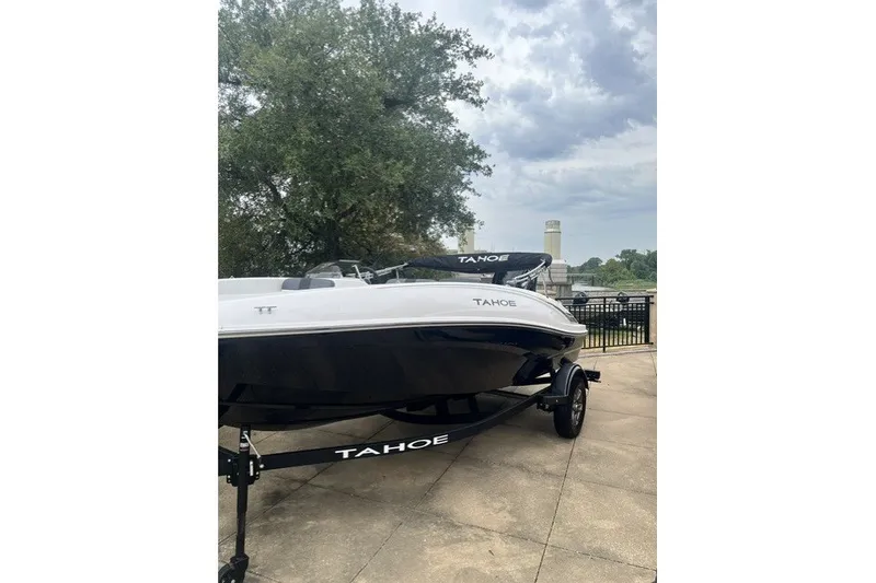 Slide: The Image of 2026 Tahoe T16 boat on trailer, parked outdoors under cloudy sky. - 9