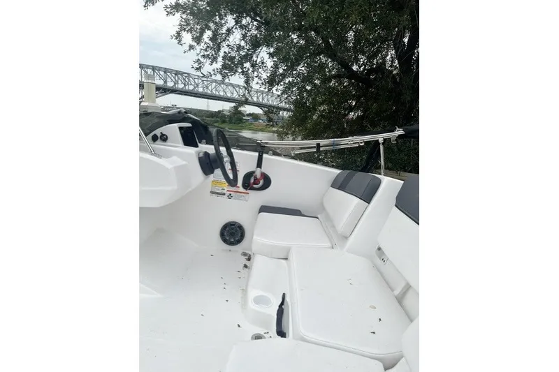Slide: The Image of 2026 Tahoe T16 boat interior with seating, steering wheel, and scenic bridge view. - 1