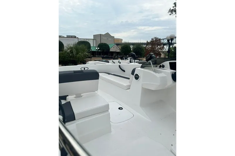Slide: The Image of 2026 Tahoe T16 boat interior with seating and controls, set against an urban backdrop. - 2
