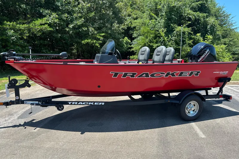 The Image of 2026 Tracker Pro Guide V-16 SC boat on trailer, red exterior, parked outdoors. - 0