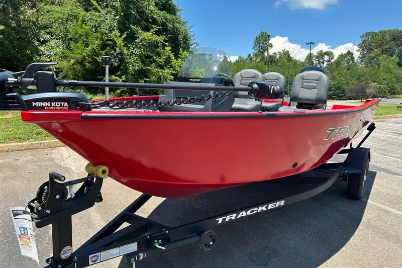 Slide: The Image of Red 2026 Tracker Pro Guide V-16 SC boat with Minn Kota PowerDrive, parked on trailer. - 2