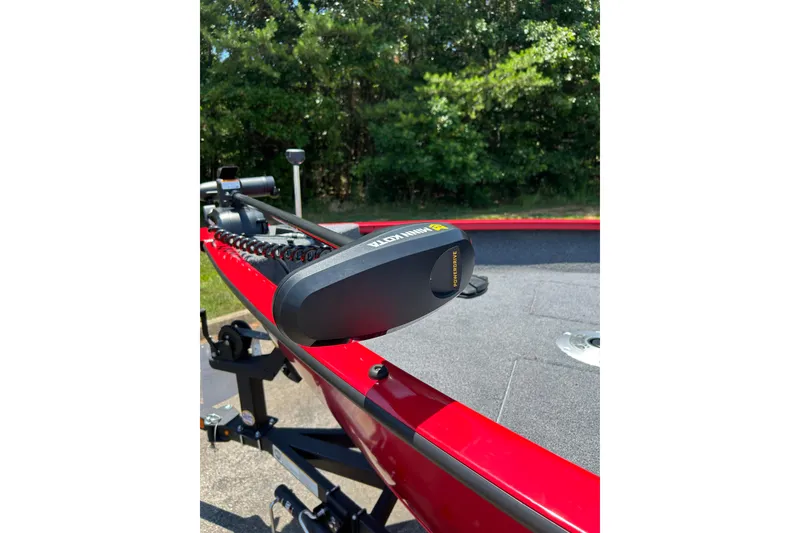 Slide: The Image of 2026 Tracker Pro Guide V-16 SC boat with Minn Kota trolling motor, red exterior, parked outdoors. - 5