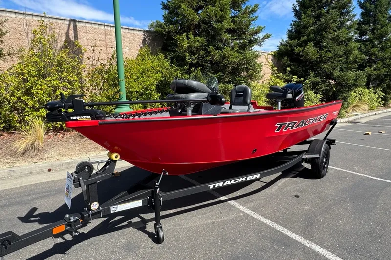 Slide: The Image of Red 2026 Tracker Pro Guide V-16 SC boat on trailer, parked outdoors. - 5