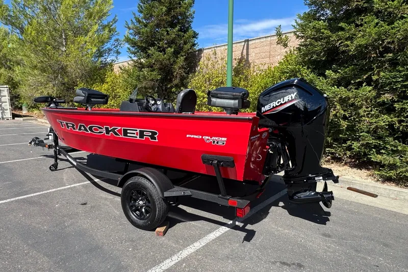 Slide: The Image of 2026 Tracker Pro Guide V-16 SC boat with Mercury engine in parking lot. - 6