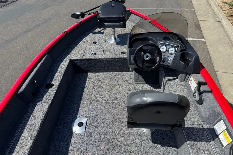 Slide: The Image of 2026 Tracker Pro Guide V-16 SC boat interior with steering console and seating. - 11