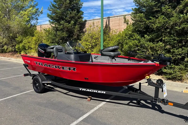 Slide: The Image of 2026 Tracker Pro Guide V-16 SC boat in vibrant red on a trailer, parked outdoors. - 3