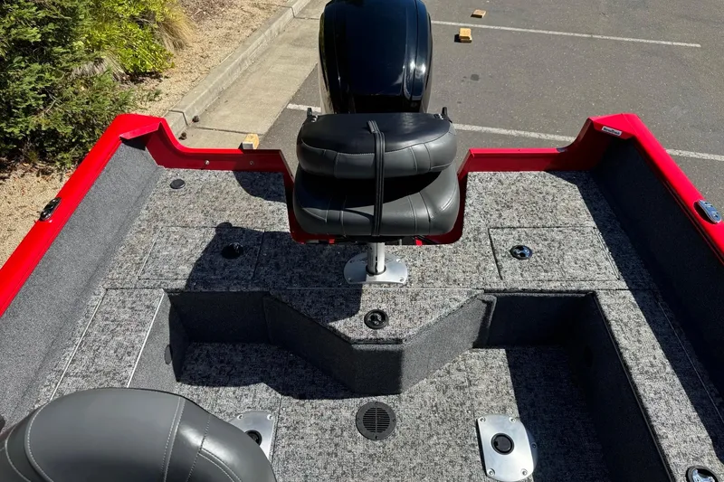 Slide: The Image of 2026 Tracker Pro Guide V-16 SC boat interior with gray carpet and black seat. - 7