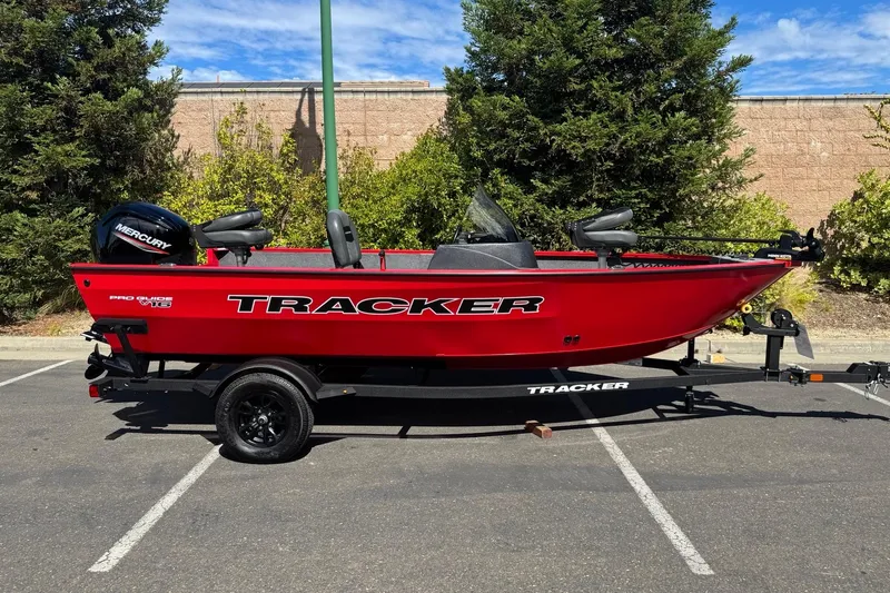 The Image of 2026 Tracker Pro Guide V-16 SC boat in vibrant red, parked outdoors. - 0