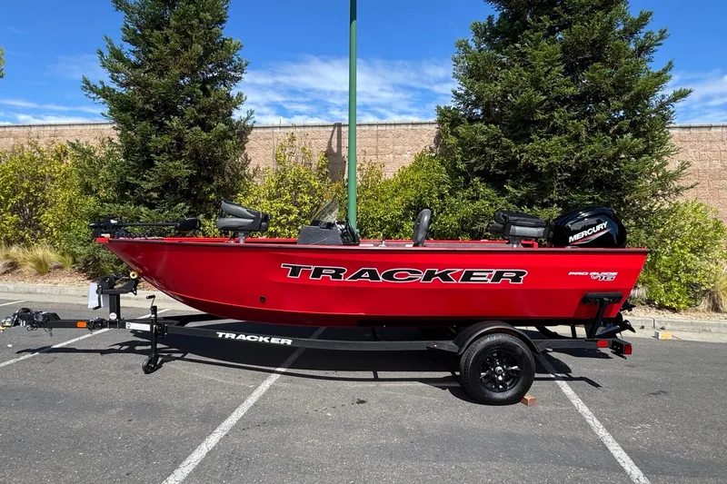 The Image of 2026 Tracker Pro Guide V-16 SC boat in vibrant red, parked outdoors. - 0