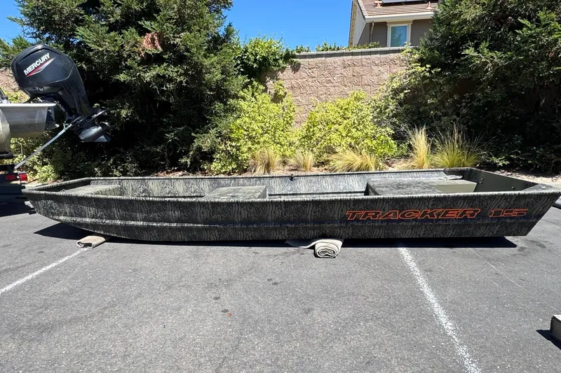 The Image of 2026 Tracker Grizzly 15 Jon boat with Mercury motor, parked outdoors. - 0