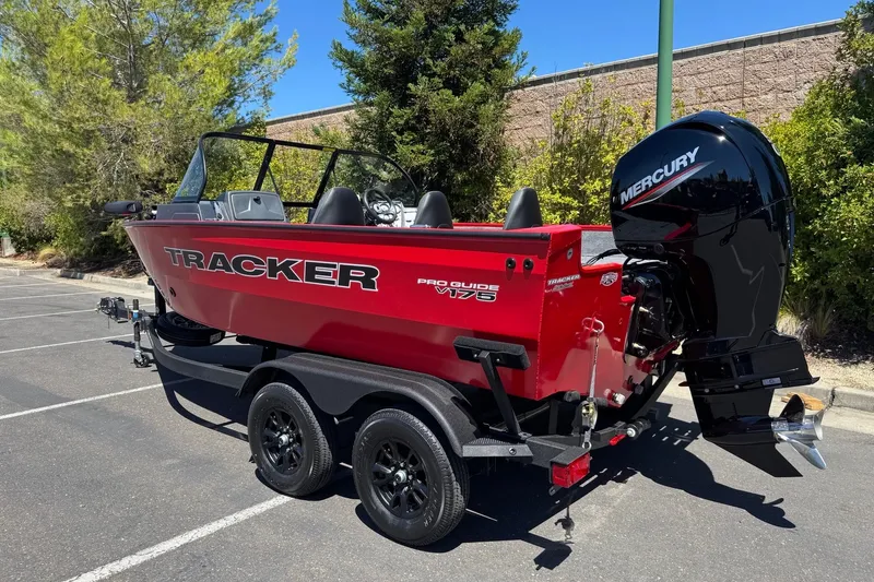 Slide: The Image of 2026 Tracker Pro Guide V-175 WT boat with Mercury engine on trailer in parking lot. - 2
