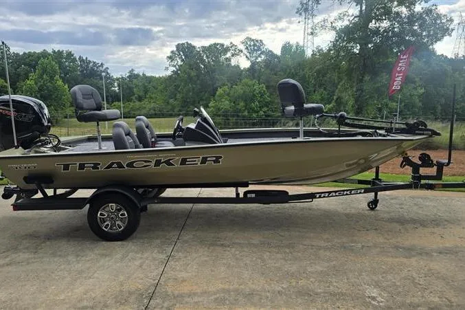 Slide: The Image of 2026 Tracker Pro Team 190 boat on trailer, parked outdoors with trees in background. - 2