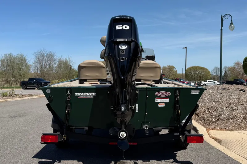 Slide: The Image of 2026 Tracker Bass Tracker Classic Limited boat with 50 HP motor, parked outdoors. - 5