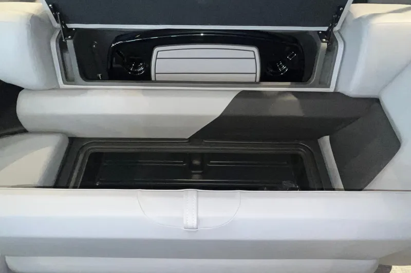 Slide: The Image of 2026 Sun Tracker Party Barge 20 DLX storage compartment with open lid and seating. - 18