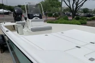 Slide: The Image of 2026 Mako Pro Skiff 17 CC boat with center console and outboard motor in a marina setting. - 3
