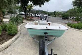 Slide: The Image of 2026 Mako Pro Skiff 17 CC boat on trailer in a parking lot setting. - 1