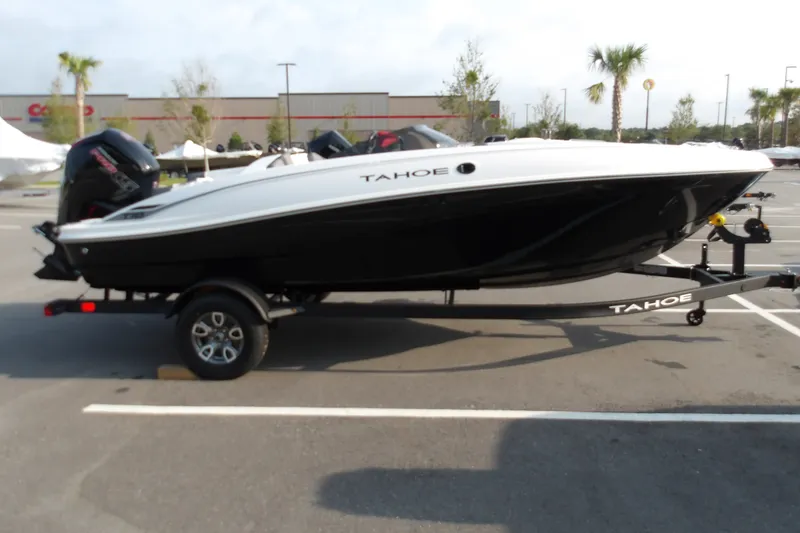 The Image of 2026 Tahoe T18 boat on trailer in parking lot, featuring sleek black and white design. - 0