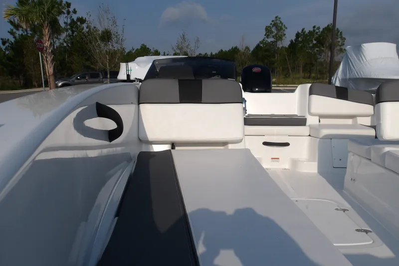 Slide: The Image of 2026 Tahoe T18 boat interior with white and gray seating, parked outdoors. - 17