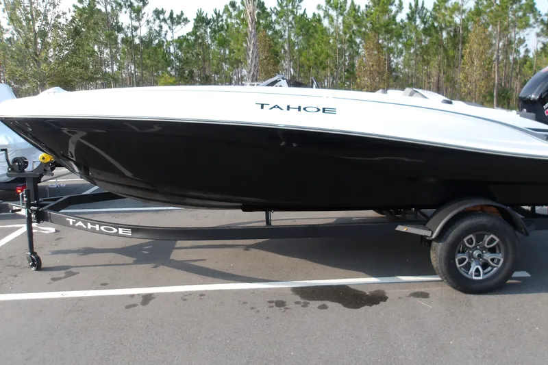 Slide: The Image of 2026 Tahoe T18 boat on trailer in parking lot, surrounded by trees. - 1