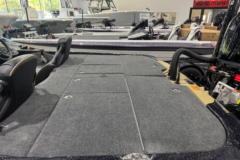 Slide: The Image of 2026 Skeeter ZXE20 boat interior with carpeted deck and seating in showroom. - 9