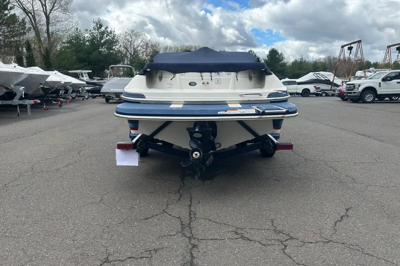 Slide: The Image of 2017 Larson LX 185S I/O boat, rear view, parked outdoors on a cloudy day. - 12