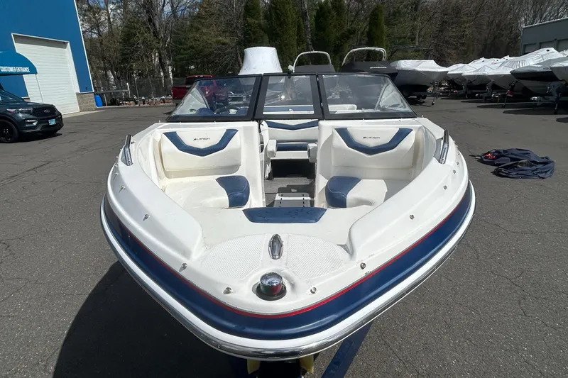 Slide: The Image of 2017 Larson LX 185S I/O boat with white and blue seating, parked outdoors. - 5