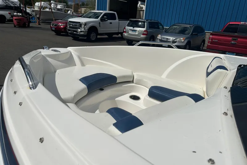 Slide: The Image of 2017 Larson LX 185S I/O boat with white and blue seating, parked outdoors. - 6