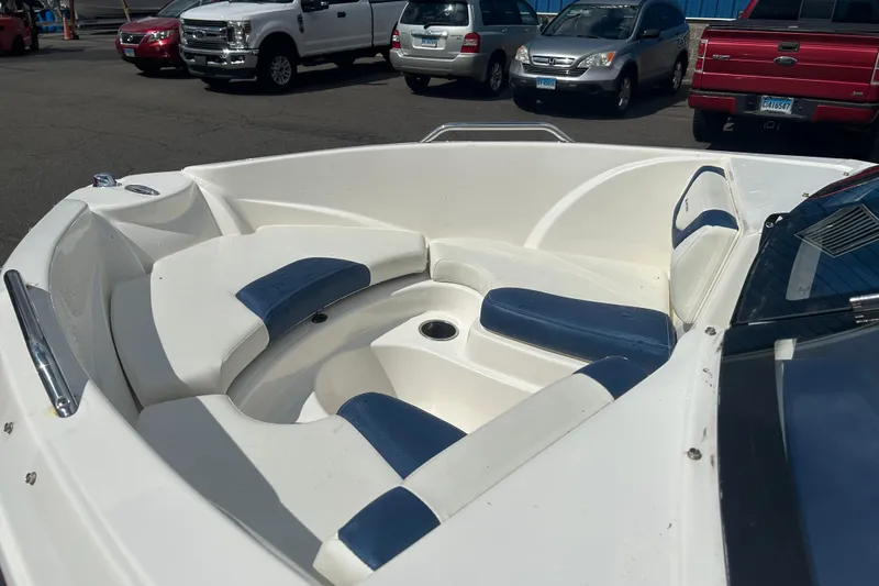 Slide: The Image of 2017 Larson LX 185S I/O boat interior with white and blue seating in a parking lot. - 7