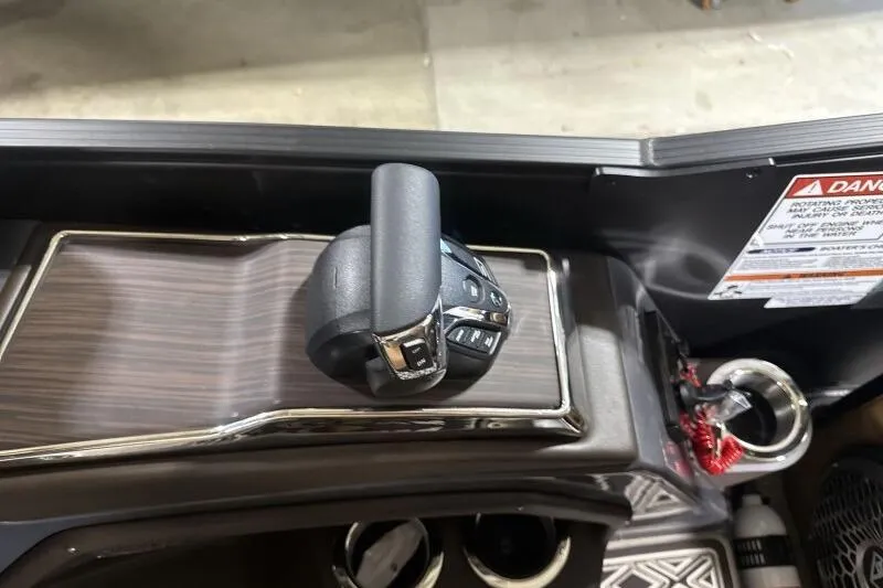 Slide: The Image of Throttle control panel of 2026 Bennington R 23 RSBA boat, featuring sleek design and warning label. - 11