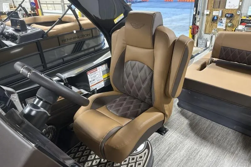 Slide: The Image of Captain's chair in 2026 Bennington R 23 RSBA boat, featuring luxurious brown upholstery. - 12
