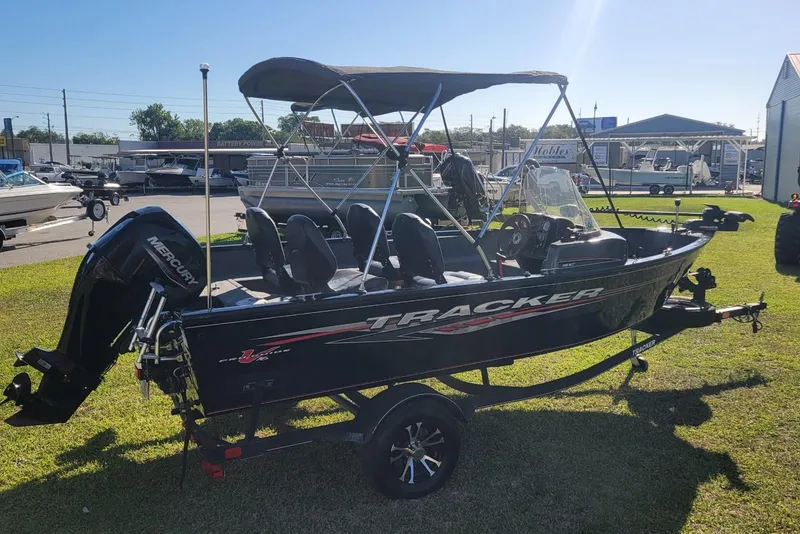 Slide: The Image of 2020 Tracker Pro Guide V-16 SC boat with canopy on grassy area. - 3