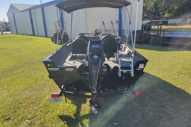 Slide: The Image of 2020 Tracker Pro Guide V-16 SC boat with outboard motor on grassy area. - 5