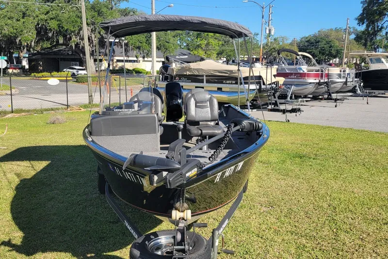 Slide: The Image of 2020 Tracker Pro Guide V-16 SC boat on grass, with canopy and seats visible. - 6
