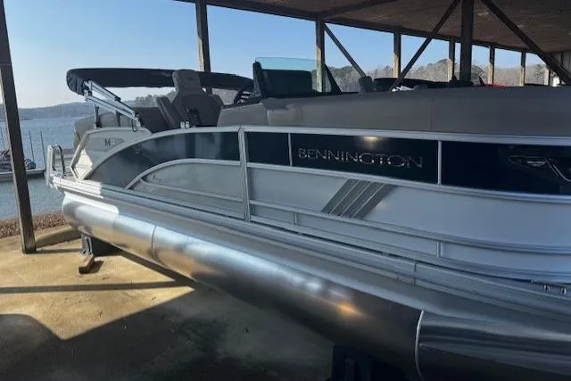 The Image of 2026 Bennington 22 MFB pontoon boat docked under a shelter by the water. - 0