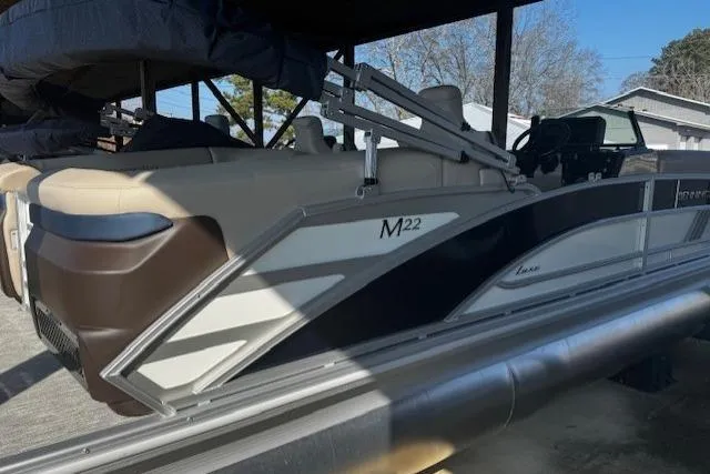 Slide: The Image of 2026 Bennington 22 MFB pontoon boat with sleek design under a covered dock. - 3