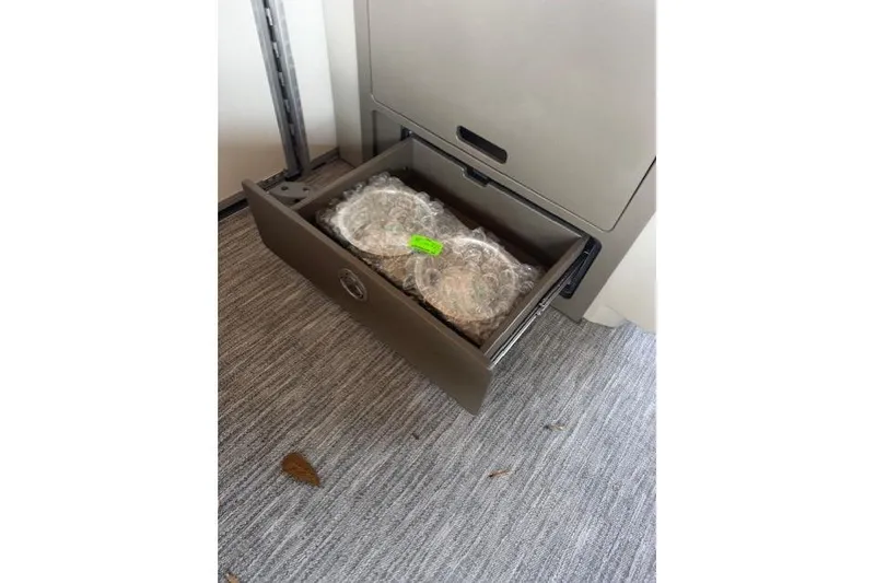 Slide: The Image of Open drawer with bubble-wrapped items inside, on a carpeted floor. - 9