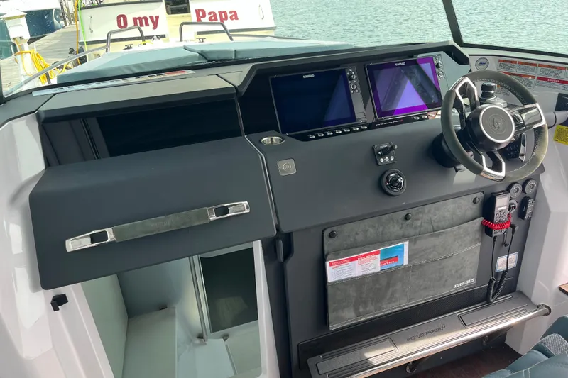 Slide: The Image of 2024 Axopar 37 XC Cross Cabin helm with dual displays and modern steering wheel. - 11