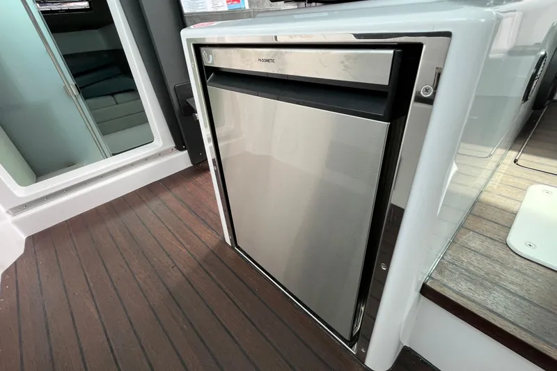 Slide: The Image of 2024 Axopar 37 XC Cross Cabin interior with sleek stainless steel refrigerator. - 15