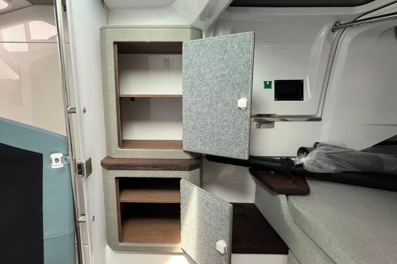 Slide: The Image of 2024 Axopar 37 XC Cross Cabin interior storage compartments with open doors. - 23