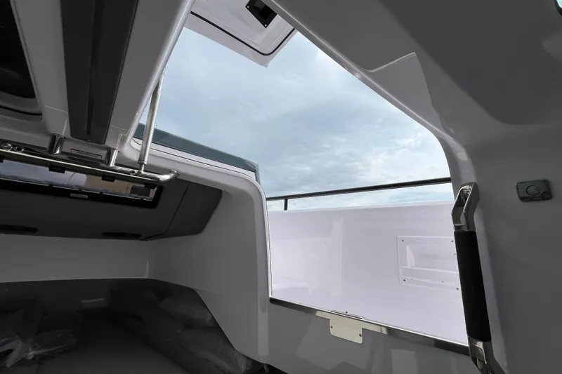 Slide: The Image of 2024 Axopar 37 XC Cross Cabin interior view with open hatch and sky. - 25