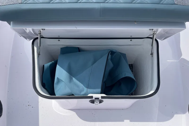 Slide: The Image of Open storage compartment on 2024 Axopar 37 XC Cross Cabin with blue fabric inside. - 4