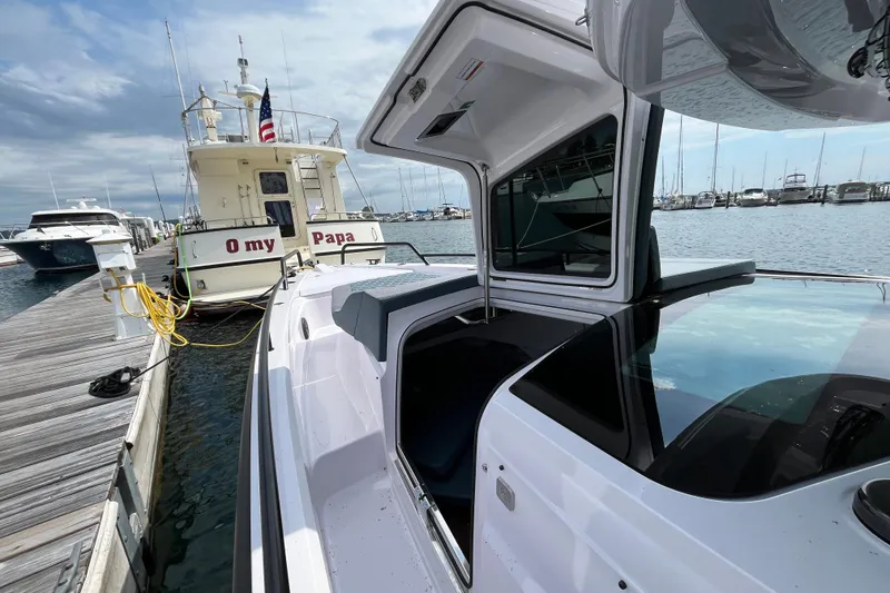 Slide: The Image of 2024 Axopar 37 XC Cross Cabin docked beside a boat named "O my Papa." - 7