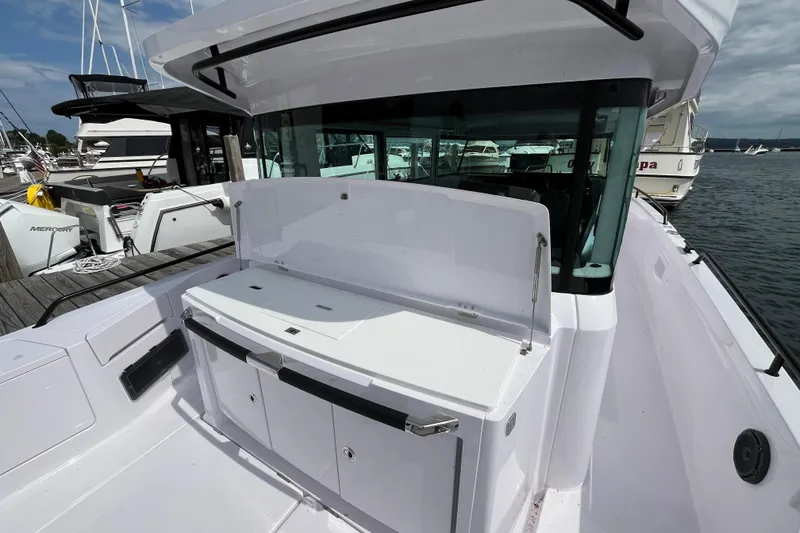 Slide: The Image of 2024 Axopar 37 XC Cross Cabin boat docked, showcasing sleek design and spacious deck area. - 8