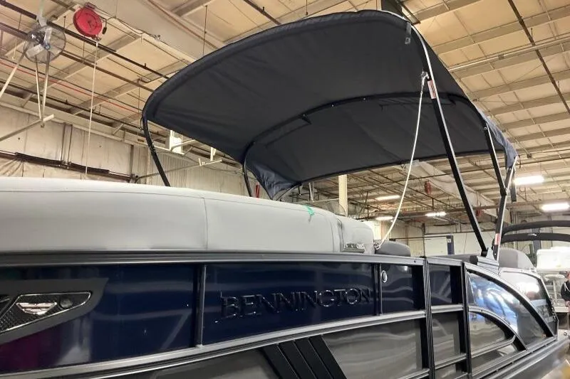 Slide: The Image of 2026 Bennington 22 MSB pontoon boat with canopy in a warehouse setting. - 2