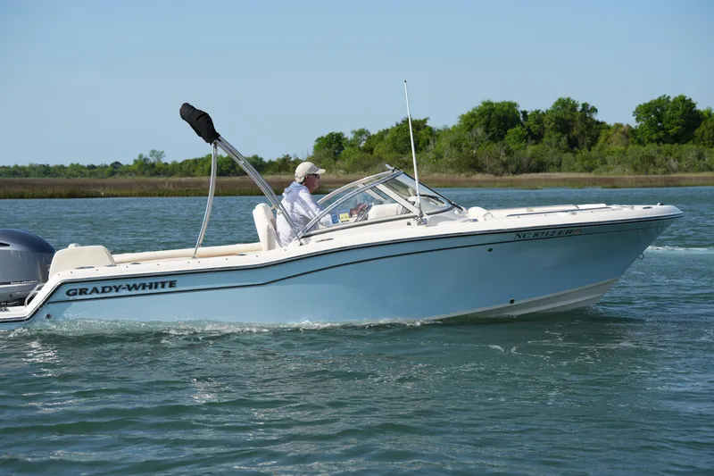 The Image of 2021 Grady-White Freedom 215 boat cruising on a calm lake with lush greenery. - 0