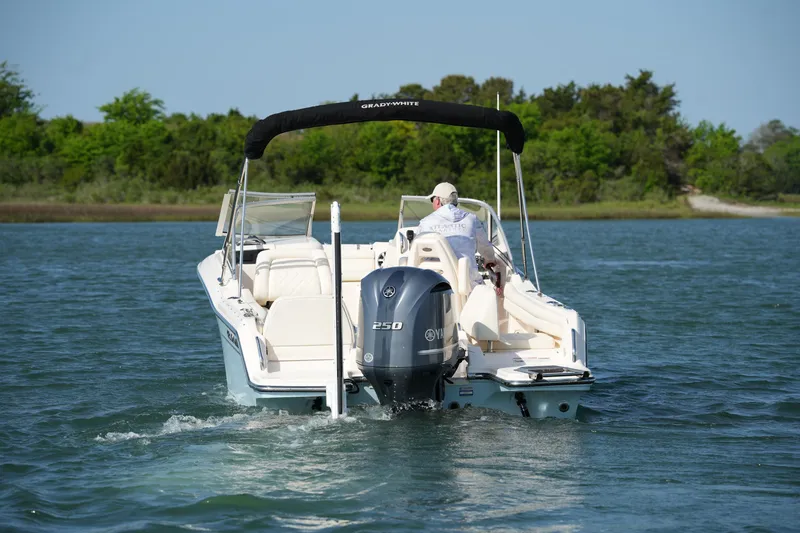 Slide: The Image of 2021 Grady-White Freedom 215 boat cruising on a serene lake with lush greenery. - 11