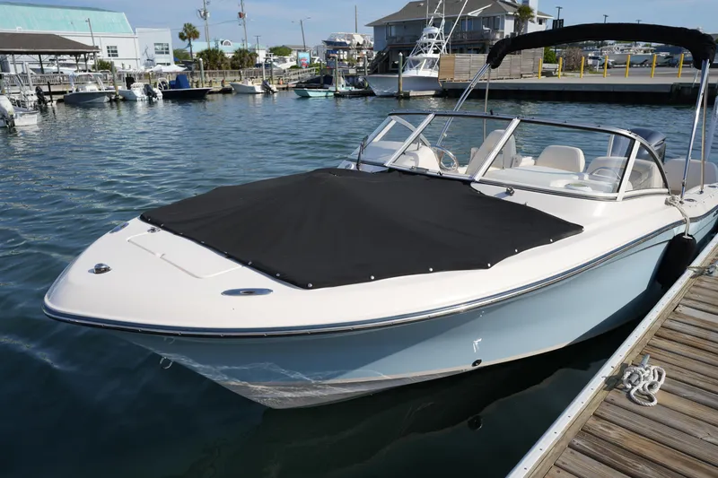 Slide: The Image of 2021 Grady-White Freedom 215 boat docked with black cover, calm marina setting. - 13