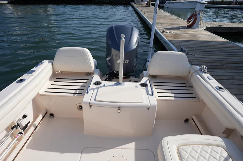 Slide: The Image of 2021 Grady-White Freedom 215 boat interior with seating and outboard motor at dock. - 15