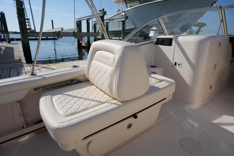 Slide: The Image of 2021 Grady-White Freedom 215 boat interior with white cushioned seating at dock. - 20