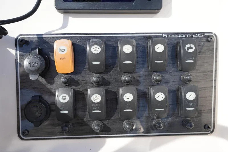 Slide: The Image of Control panel of 2021 Grady-White Freedom 215 boat with labeled switches. - 28